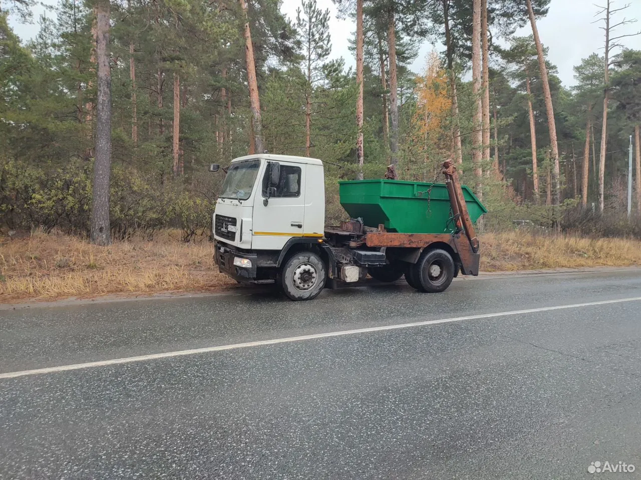 Загрузка крупногабаритного мусора в контейнер на стройплощадке
